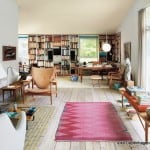 Finn Juhl’s own house is a textbook example of his project as an architect and as a furniture designer. The house at Kratvænget 15 in Charlottenlund, north of Copenhagen was built in 1942. It is situated in rural surroundings on a 1700 m² site adjoining the park at Ordrupgaard. 

The house is composed of two blocks standing at right-angles to each other. In one block is a large living room and a small study, while the second block houses the kitchen, dining room, bedrooms and bathroom. The two blocks are joined by an entrance hall which opens to the garden. The house is an early example of open-plan, with a characteristic view through its rooms. Although each room has its own clear function, it is always possible to look from one room to the next as you walk through the house and there is always a view of the garden. The ceilings are painted in pale light yellow and when they reflect the light from outside, they resemble the roof of a tent with light shining through. The house is brick-built and the façade is plastered in a grey-white shade which offers it a soft, matt effect. Therefore the house appears light against the contrasting dark woodland backdrop.
